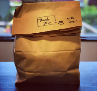 A picture of a large brown paper bag with a note that says thank you