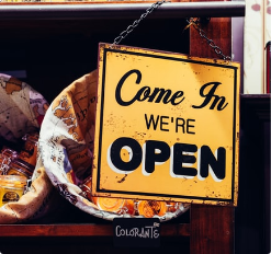 A picture of a sign in the window saying come on in we're open